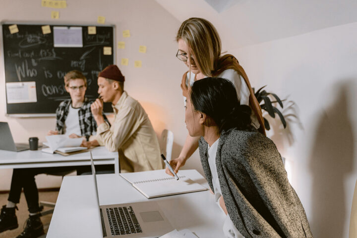 women standing next to other women teaching