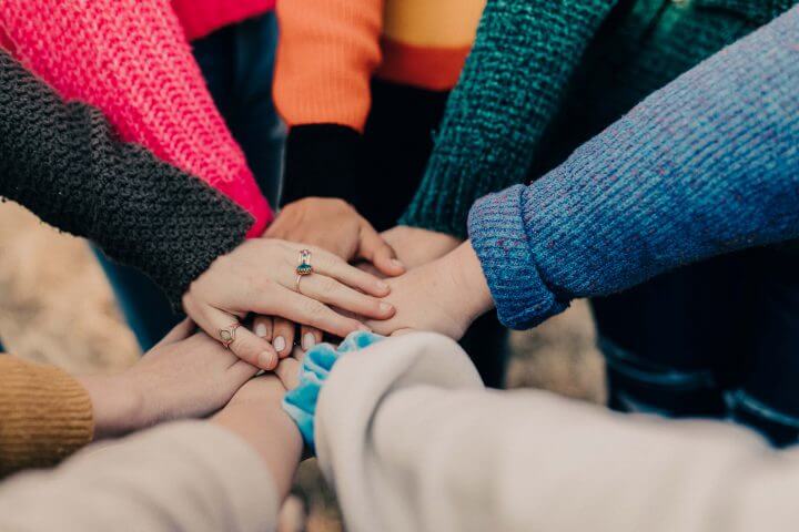 Hands together in photo showing users of a Dynamics 365 for Charities System