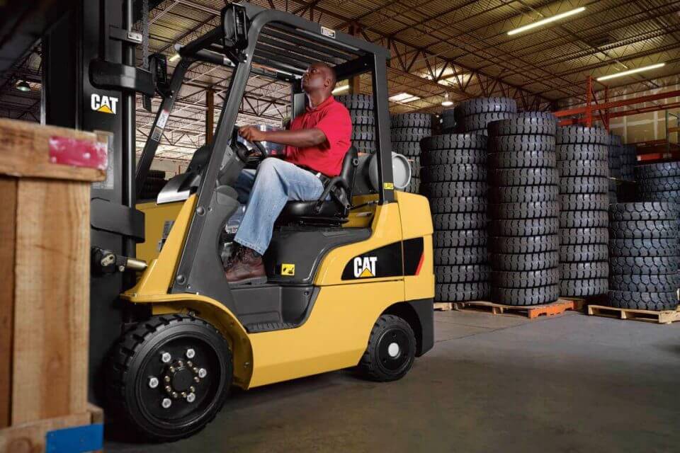 Male operating forklift in a factory