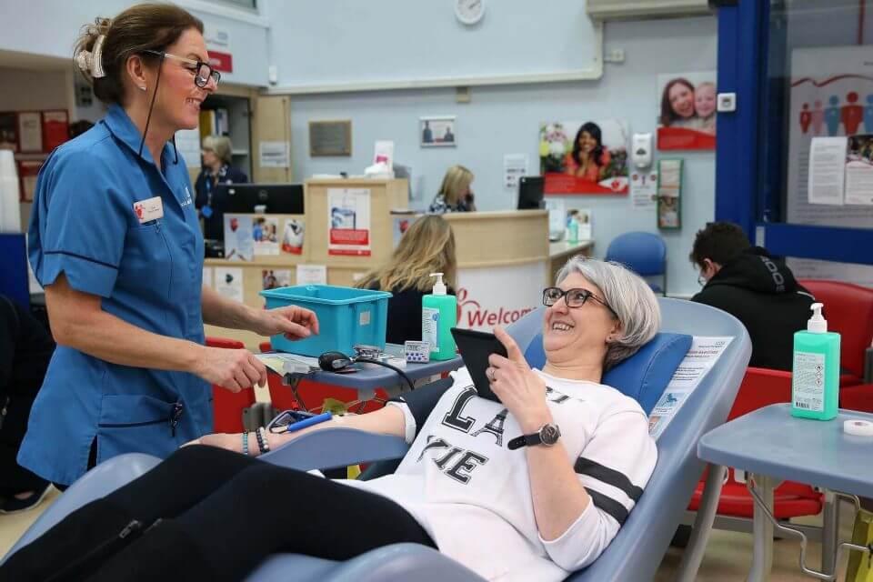 Woman laying on bed about to give blood
