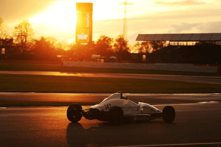 Moorgate finance racing car driving round track at sunset