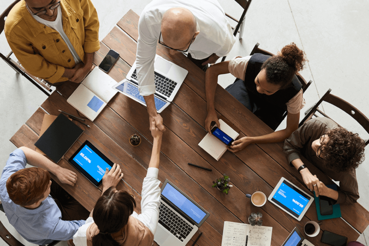 Group of people sitting around table all on laptops