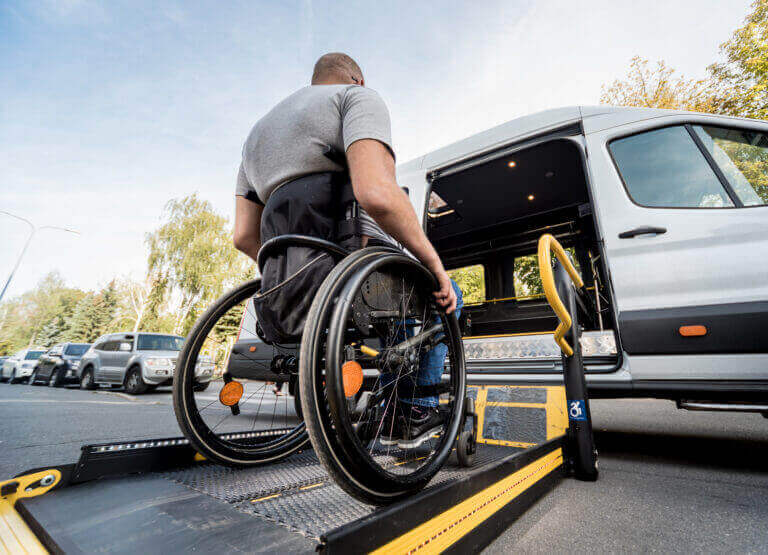 male in wheelchair using ramp to get into a van