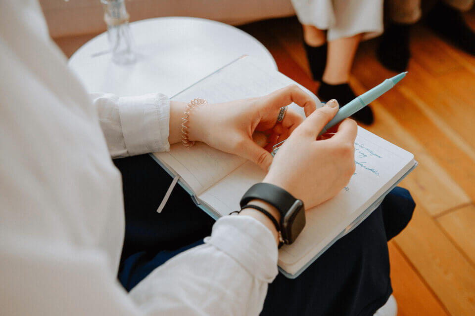 women in talking therapy writing on notepad