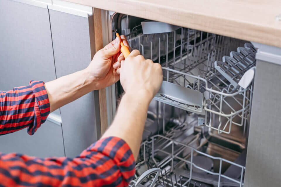 Person fixing dishwasher