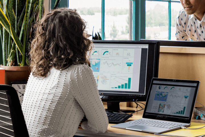 women on chair looking at Power-BI Dashboard